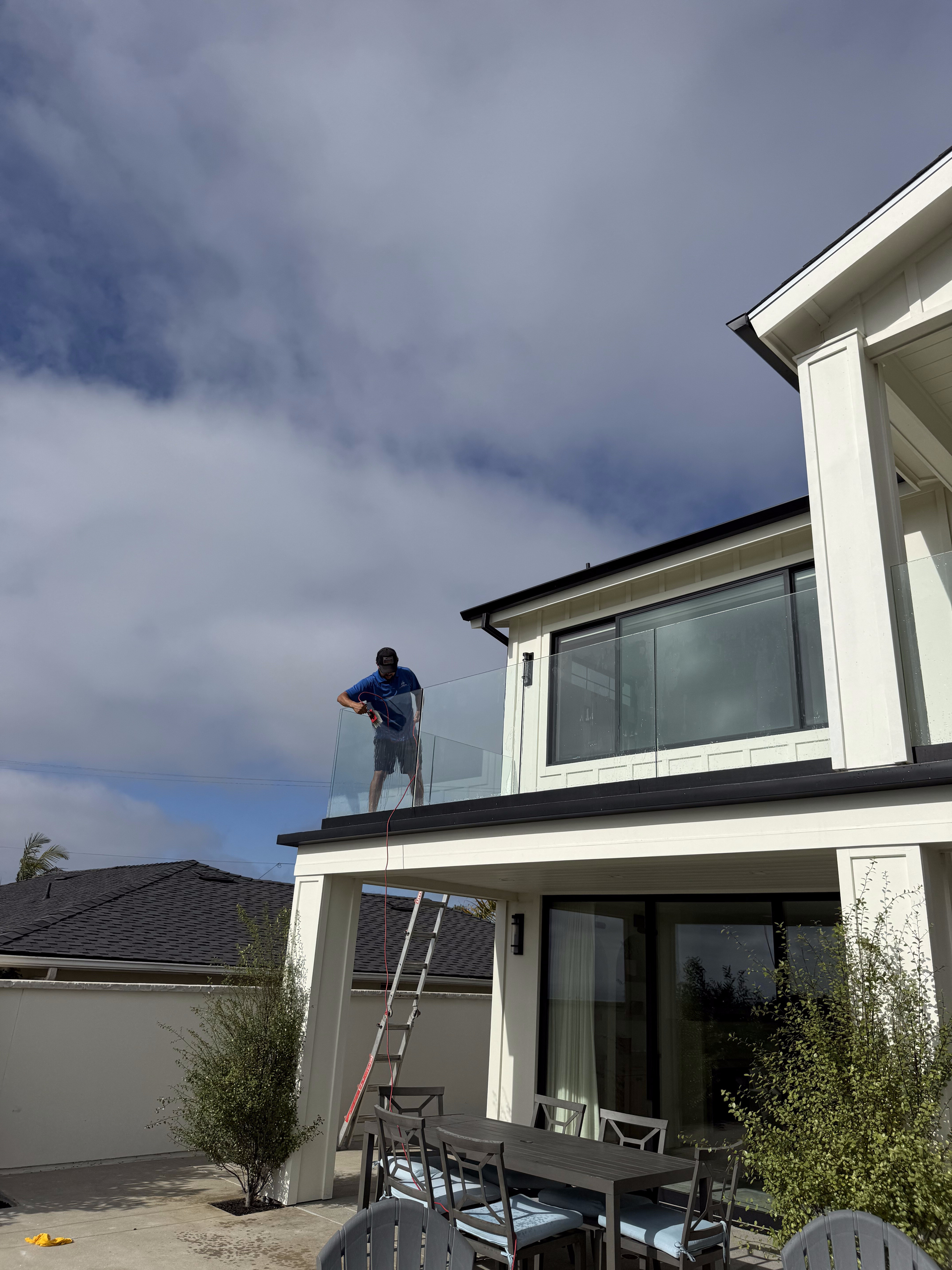 Glass balcony railing cleaning at a modern home